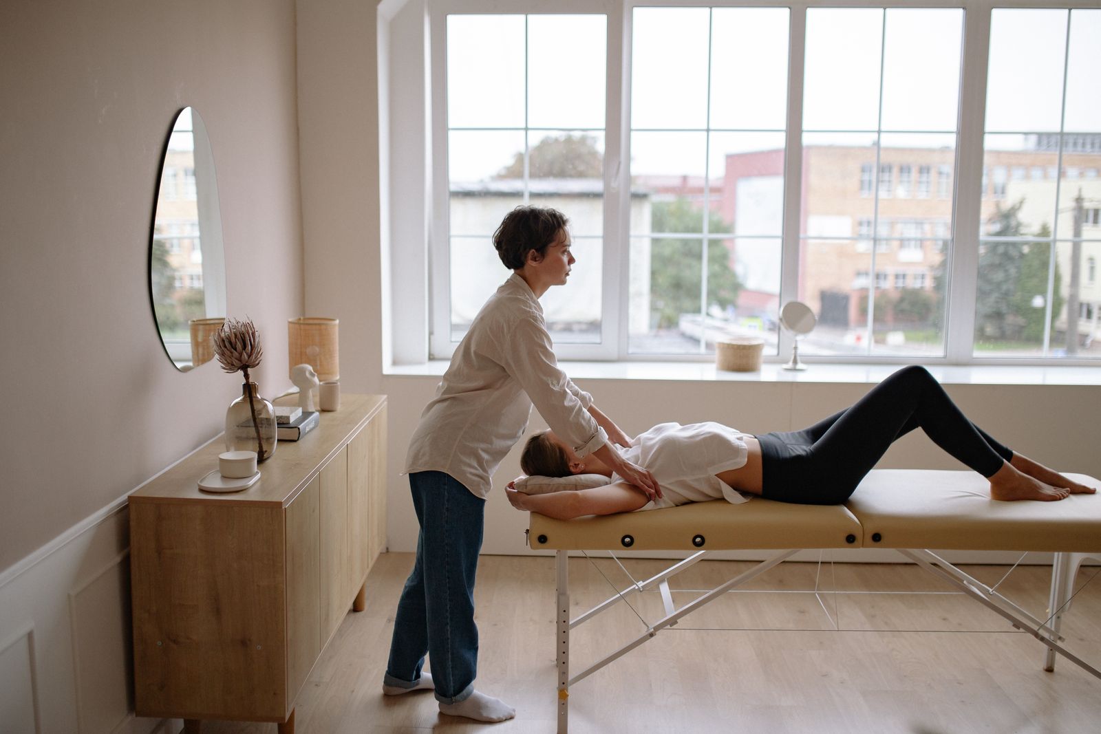 Massage therapist working with a client on a treatment table